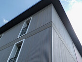 L'élégant profil vertical de la façade en bois met en valeur la construction